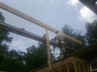 Carpenter setting a ridge beam over a new addition frame — Ice Dam Removal by Roofing Brothers in Nunnelly