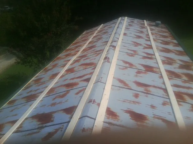 Rusted metal roof panels with new wood purlins before replacement — Storm Damage Roof Repair in Nunnelly by Roofing Brothers