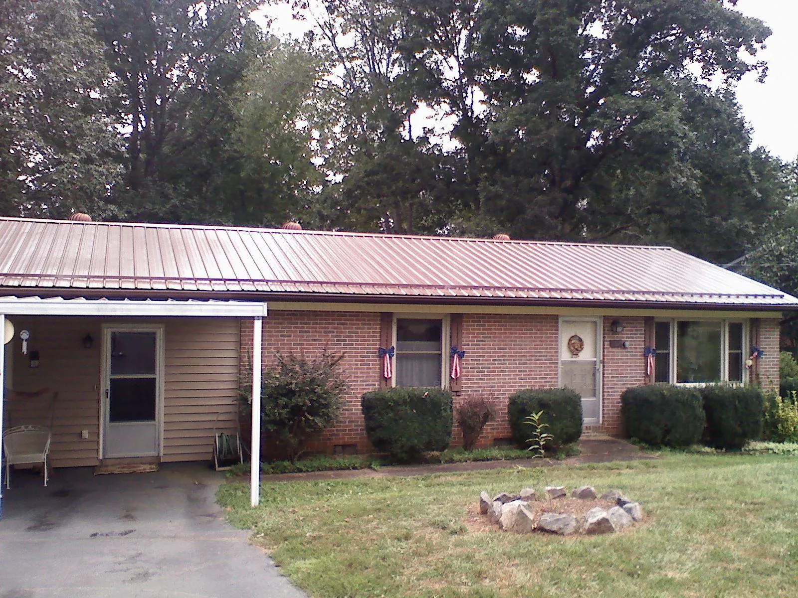 Bronze metal roof and carport on a brick ranch home — Roof Repair work by our crew in Nunnelly